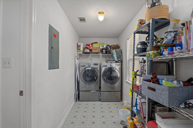 clothes washing area with visible vents, washer and clothes dryer, electric panel, laundry area, and a textured ceiling