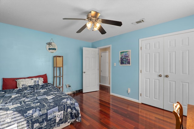 bedroom with a ceiling fan, wood finished floors, visible vents, baseboards, and a closet