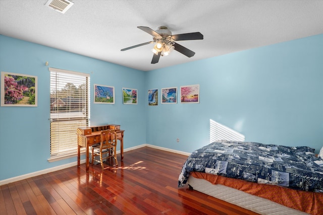 bedroom featuring hardwood / wood-style floors, baseboards, visible vents, and a ceiling fan