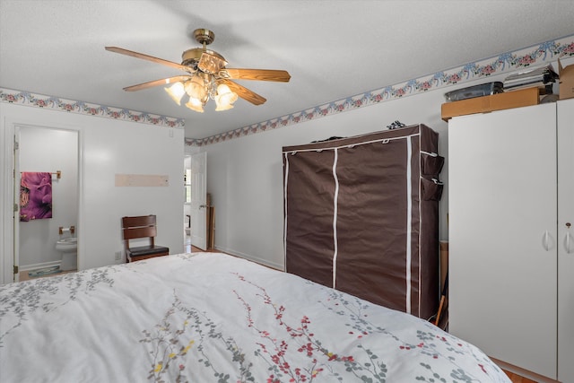 bedroom with a textured ceiling, connected bathroom, and ceiling fan