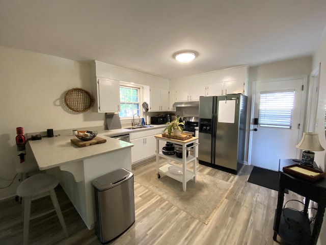 2416 Forest Park Rd, Augusta, GA 30904 - kitchen featuring stainless steel fridge, a peninsula, light countertops, light wood-type flooring, and white cabinetry