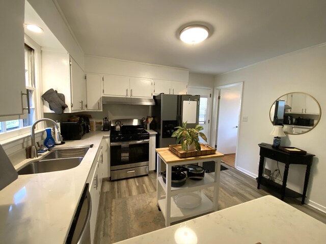2416 Forest Park Rd, Augusta, GA 30904 - kitchen featuring stainless steel gas range, under cabinet range hood, fridge with ice dispenser, light countertops, and wood finished floors
