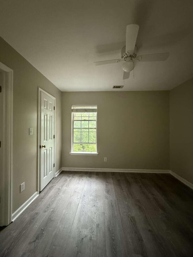 unfurnished room with dark wood finished floors, baseboards, and ceiling fan