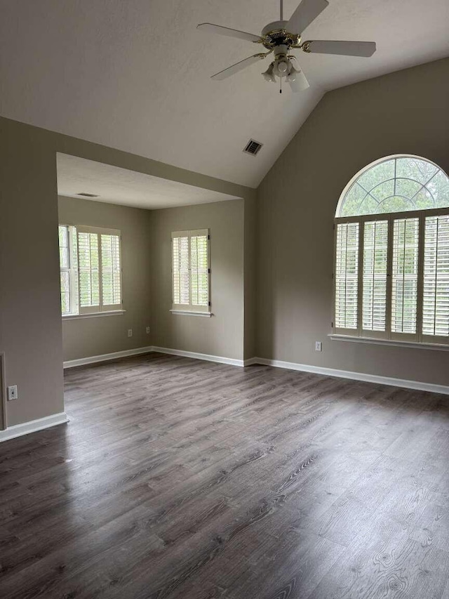 spare room featuring ceiling fan, lofted ceiling, dark wood finished floors, and baseboards
