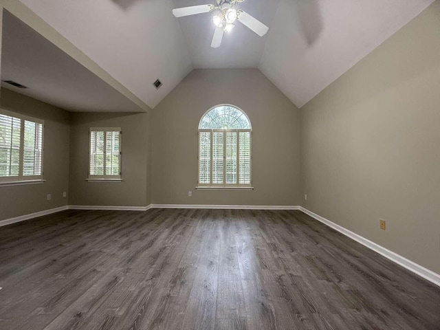 unfurnished room featuring plenty of natural light, dark wood-style flooring, ceiling fan, baseboards, and vaulted ceiling