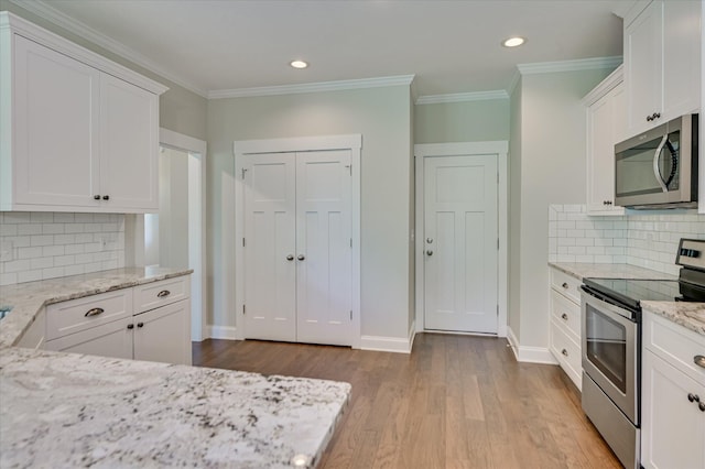 997 Glenhaven Dr, Evans, GA 30809 - kitchen with stainless steel appliances, white cabinets, wood finished floors, light stone counters, and backsplash