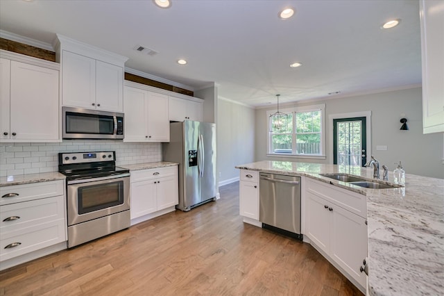 997 Glenhaven Dr, Evans, GA 30809 - kitchen with stainless steel appliances, ornamental molding, white cabinetry, decorative backsplash, and light wood-type flooring