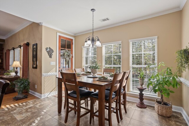 dining area featuring tile patterned flooring, ornamental molding, and a notable chandelier