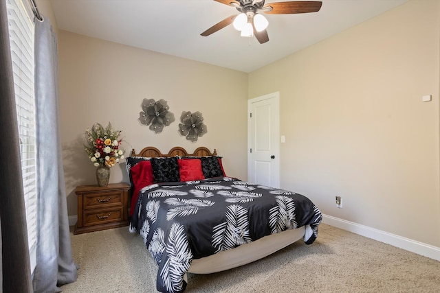 carpeted bedroom featuring multiple windows and ceiling fan