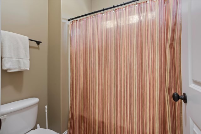 bathroom featuring a shower with curtain and toilet