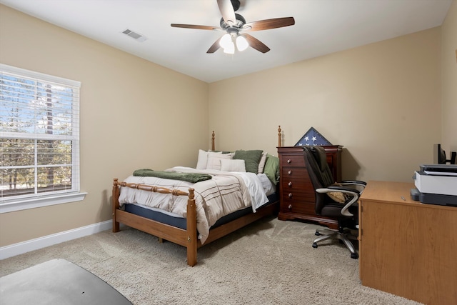 bedroom with light carpet, multiple windows, and ceiling fan