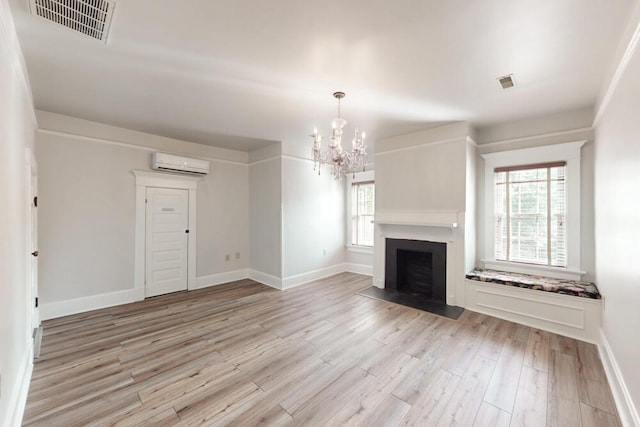 116 Jackson Rd, Jackson, SC 29831 - unfurnished living room with an AC wall unit, a chandelier, light wood finished floors, and healthy amount of natural light