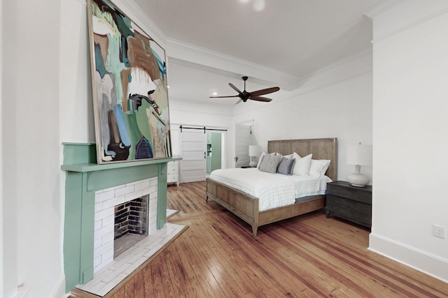 116 Jackson Rd, Jackson, SC 29831 - bedroom with a barn door, ornamental molding, hardwood / wood-style floors, baseboards, and a brick fireplace