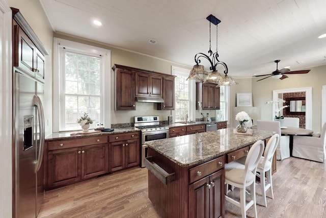 116 Jackson Rd, Jackson, SC 29831 - kitchen featuring appliances with stainless steel finishes, under cabinet range hood, light wood-type flooring, a kitchen island, and a kitchen breakfast bar