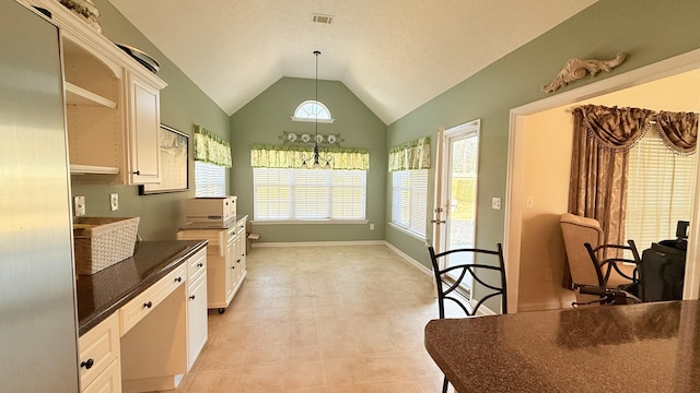 kitchen featuring visible vents, dark countertops, hanging light fixtures, vaulted ceiling, and white cabinetry