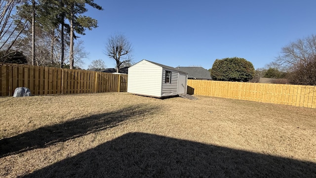 view of yard featuring an outbuilding, a shed, and a fenced backyard