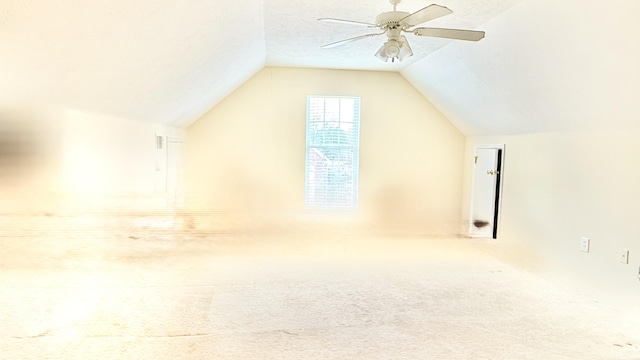 bonus room with a ceiling fan, carpet, vaulted ceiling, and a textured ceiling