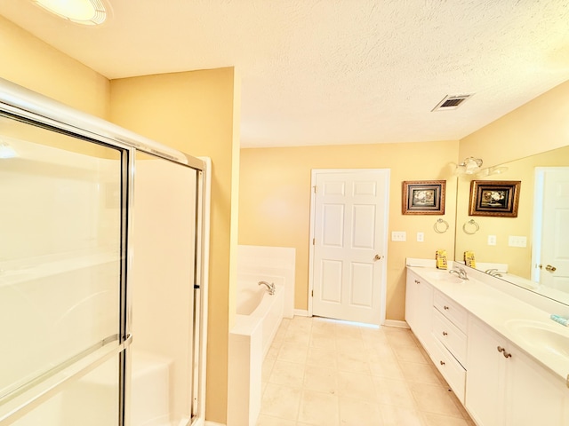 full bathroom featuring a textured ceiling, a garden tub, visible vents, a shower stall, and double vanity