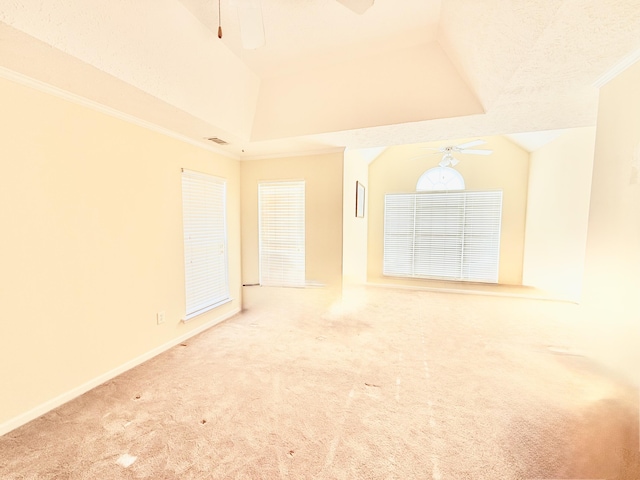 empty room featuring carpet floors, crown molding, visible vents, vaulted ceiling, and ceiling fan