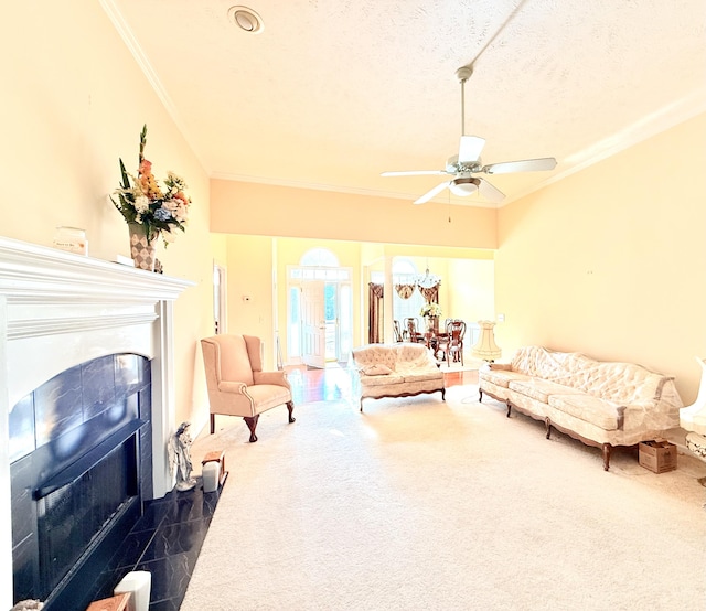 living room with ceiling fan, a textured ceiling, crown molding, and a tile fireplace