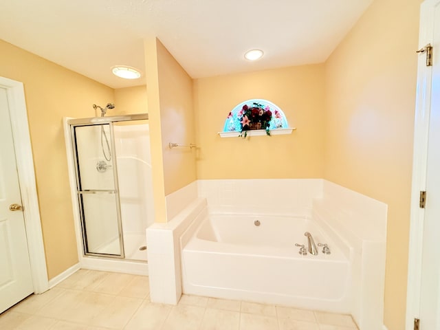 bathroom with a stall shower, a bath, and tile patterned floors