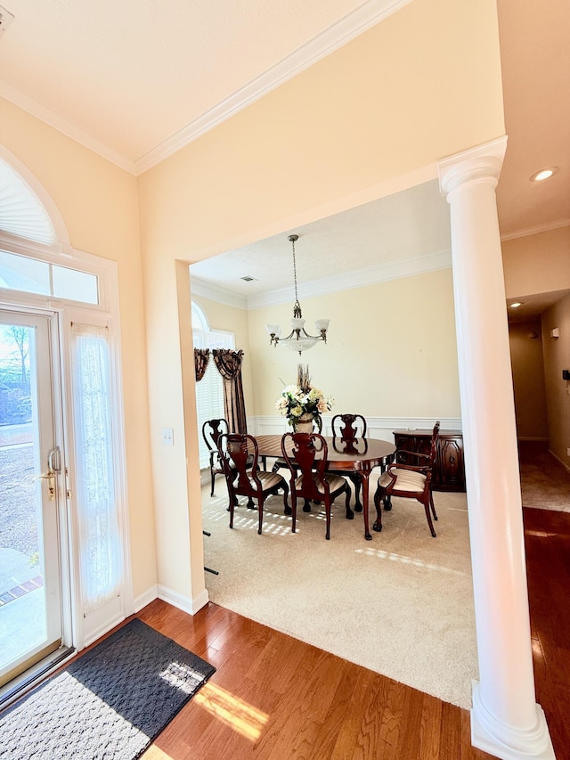 foyer entrance with crown molding, dark wood-style flooring, and decorative columns