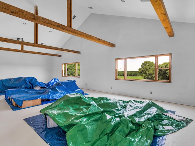 living room with beamed ceiling and high vaulted ceiling