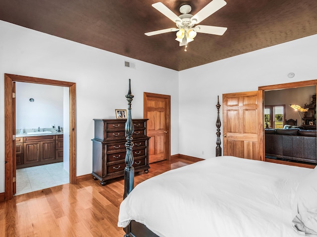 bedroom featuring light wood-type flooring, ceiling fan, sink, wooden ceiling, and connected bathroom