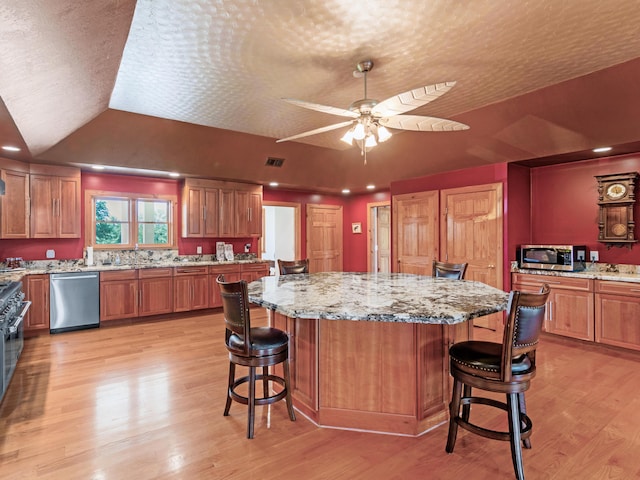 kitchen with a center island, a kitchen bar, lofted ceiling, and stainless steel appliances