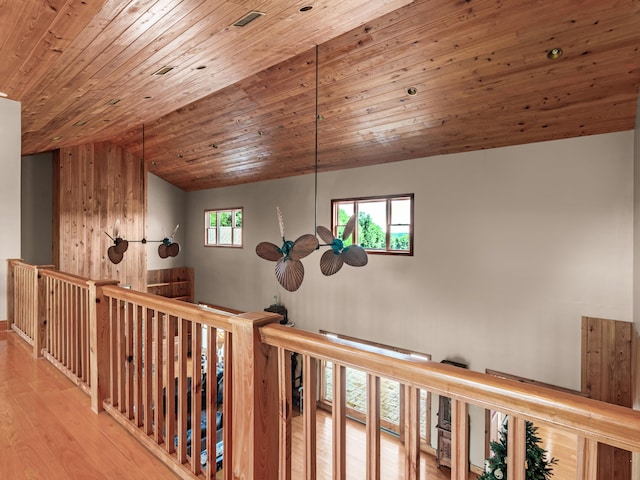 corridor with light hardwood / wood-style flooring and wood ceiling