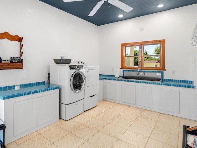 clothes washing area featuring cabinets, ceiling fan, washer and clothes dryer, sink, and light tile patterned flooring