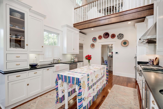 2619 Raymond Ave, Augusta, GA 30904 - kitchen featuring dark countertops, white cabinets, wall chimney exhaust hood, and wood finished floors