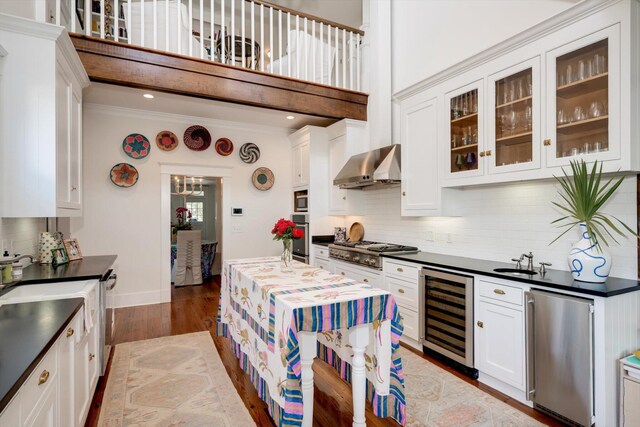 2619 Raymond Ave, Augusta, GA 30904 - kitchen featuring dark countertops, appliances with stainless steel finishes, wall chimney exhaust hood, and wine cooler