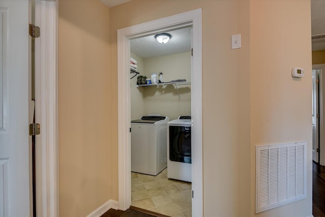 laundry area featuring independent washer and dryer and a textured ceiling