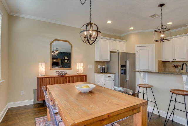 dining room featuring crown molding, dark hardwood / wood-style floors, and an inviting chandelier