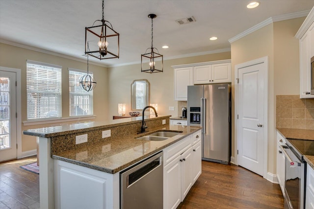 kitchen with stainless steel appliances, an island with sink, sink, and white cabinets