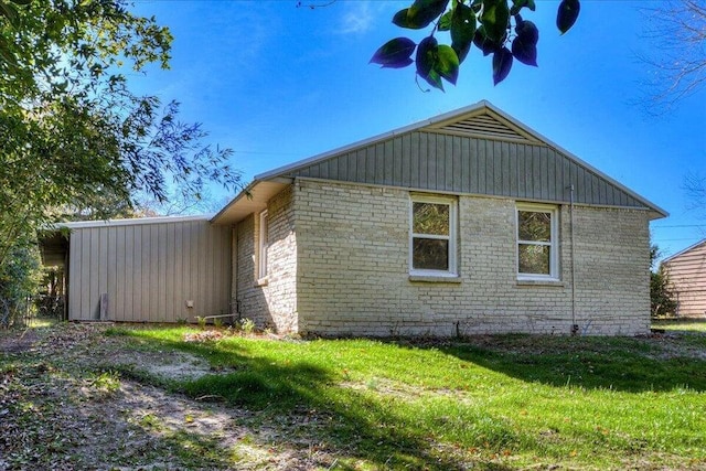 view of side of home with a yard