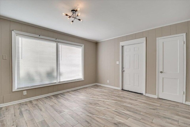 unfurnished room featuring crown molding and light hardwood / wood-style flooring