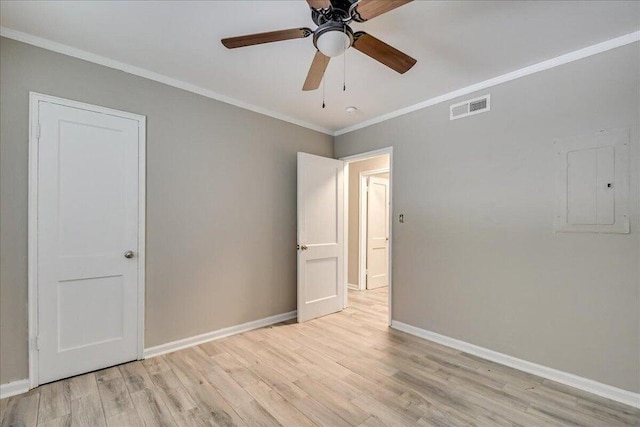 empty room featuring ceiling fan, ornamental molding, electric panel, and light hardwood / wood-style flooring