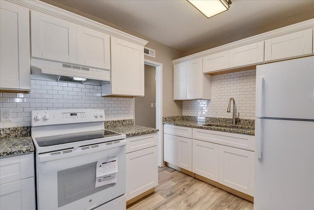 kitchen with sink, dark stone countertops, white cabinets, decorative backsplash, and white appliances