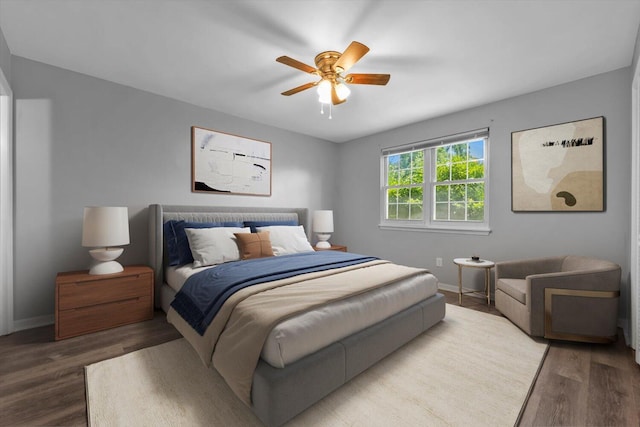 bedroom featuring wood finished floors, baseboards, and ceiling fan