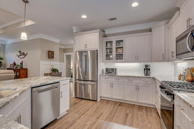 kitchen featuring tasteful backsplash, stainless steel appliances, light hardwood / wood-style floors, white cabinetry, and hanging light fixtures