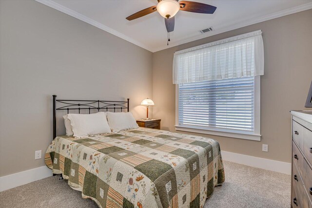 carpeted bedroom with ceiling fan and ornamental molding