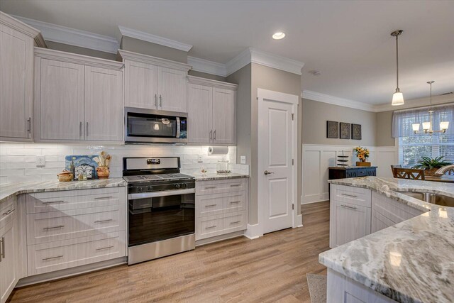 kitchen with tasteful backsplash, sink, white cabinets, and appliances with stainless steel finishes