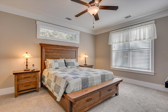 carpeted bedroom with ceiling fan and ornamental molding