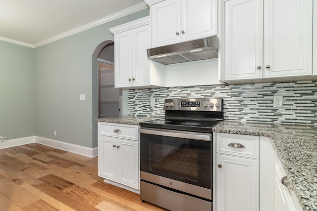 kitchen featuring light stone countertops, stainless steel electric range oven, ornamental molding, tasteful backsplash, and white cabinetry