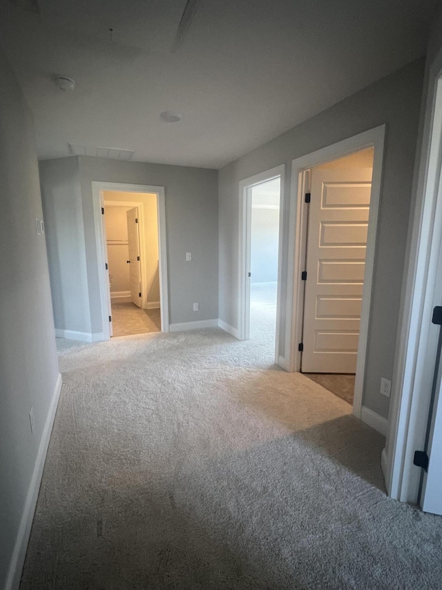 interior space featuring baseboards and light colored carpet