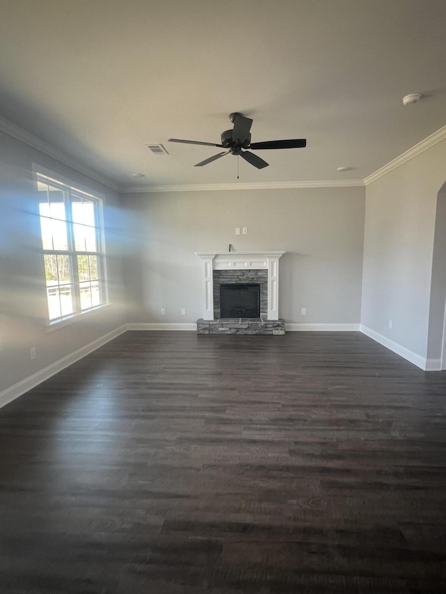 unfurnished living room with visible vents, a fireplace with raised hearth, dark wood finished floors, and ornamental molding