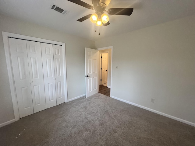 unfurnished bedroom featuring ceiling fan, a closet, and dark colored carpet