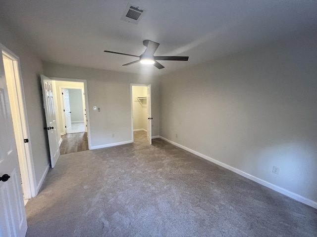 unfurnished bedroom with ceiling fan, carpet flooring, and a spacious closet